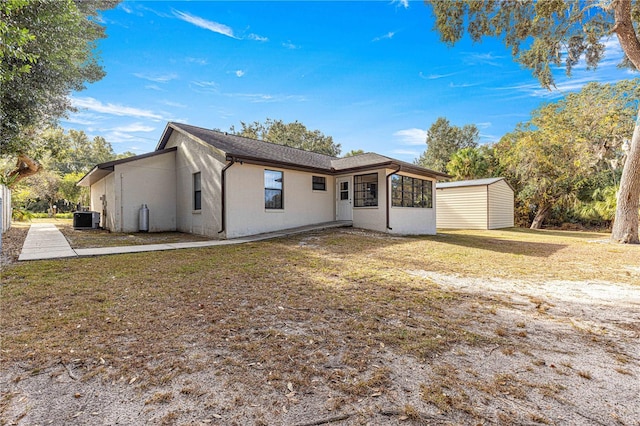 ranch-style house with cooling unit, an outdoor structure, and a front yard