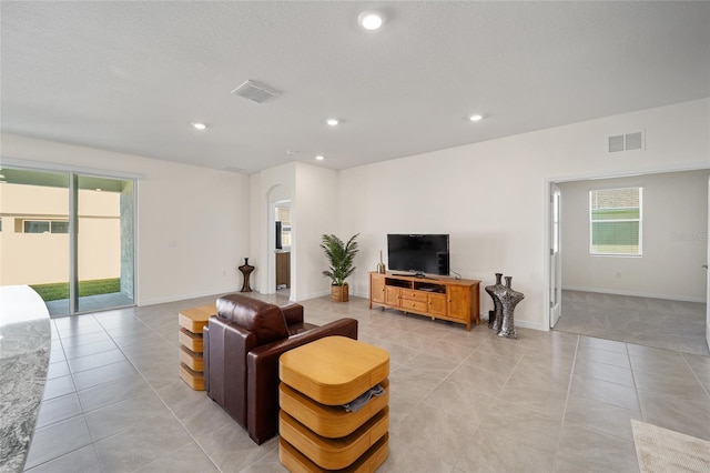 tiled living room featuring a textured ceiling