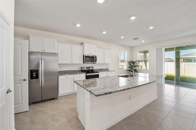 6071 SW 93rd Loop, Ocala, FL 34476 - kitchen with stainless steel appliances, a sink, white cabinets, light stone countertops, and recessed lighting