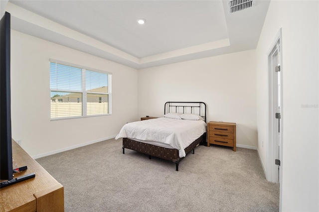 carpeted bedroom with a tray ceiling