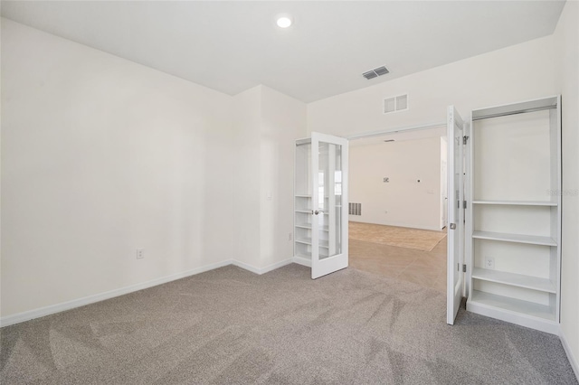 carpeted spare room with french doors