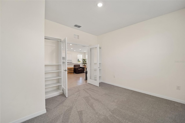 carpeted empty room featuring french doors