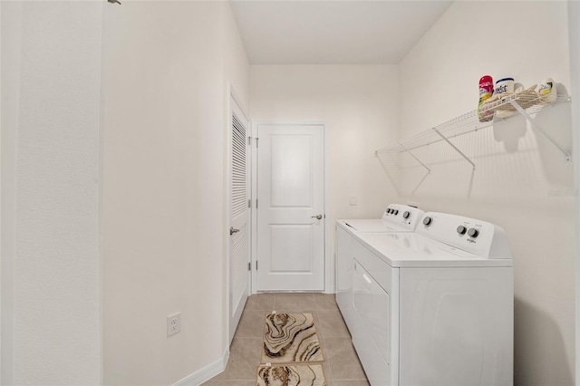 clothes washing area featuring washer and clothes dryer and light tile patterned flooring