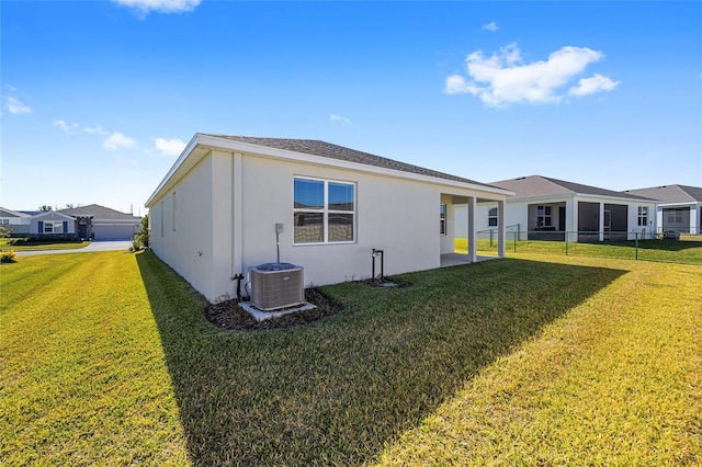 view of side of property with a patio area, a yard, and central air condition unit