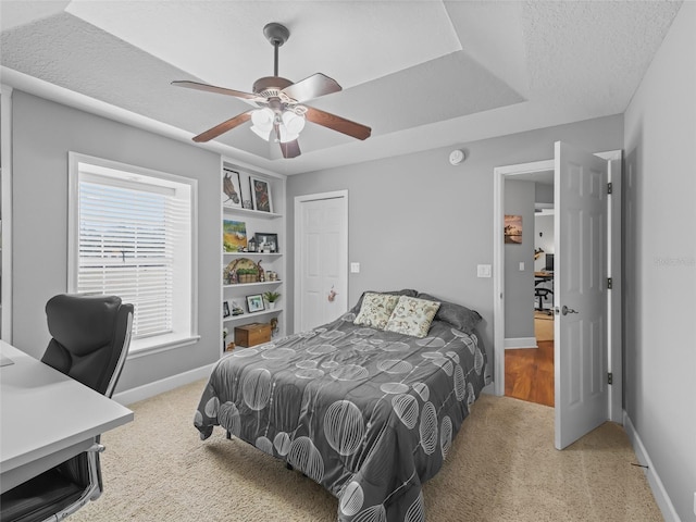 carpeted bedroom with ceiling fan and a textured ceiling