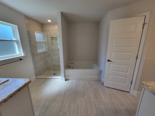 bathroom featuring shower with separate bathtub, vanity, and hardwood / wood-style flooring