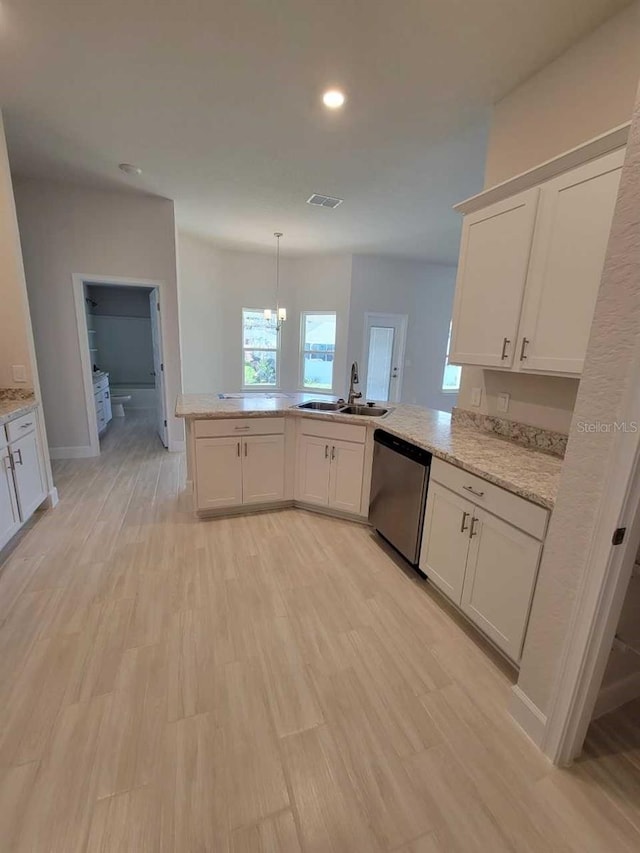 kitchen with kitchen peninsula, stainless steel dishwasher, hanging light fixtures, and sink