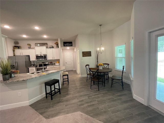 kitchen featuring white cabinets, appliances with stainless steel finishes, plenty of natural light, and sink