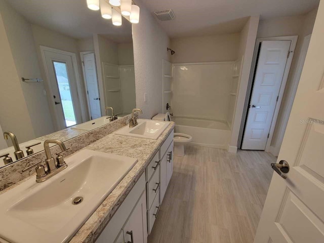 full bathroom featuring hardwood / wood-style floors, vanity,  shower combination, and toilet