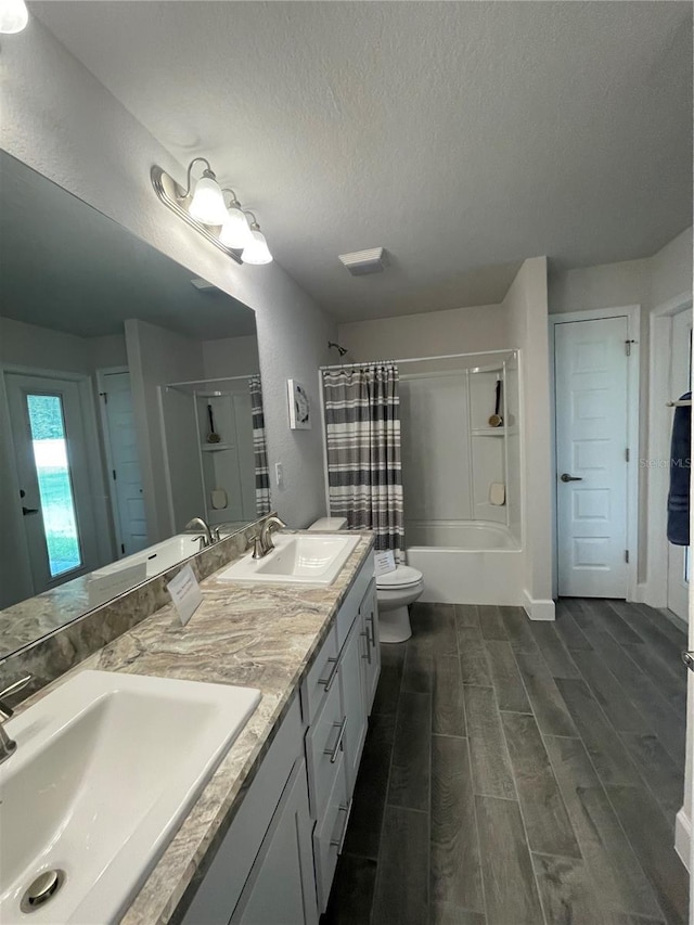 bathroom with vanity, hardwood / wood-style floors, a textured ceiling, and toilet