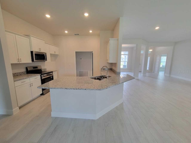8309 SW 58th Ave, Ocala, FL 34476 - kitchen featuring appliances with stainless steel finishes, light wood-style flooring, white cabinetry, light stone countertops, and recessed lighting