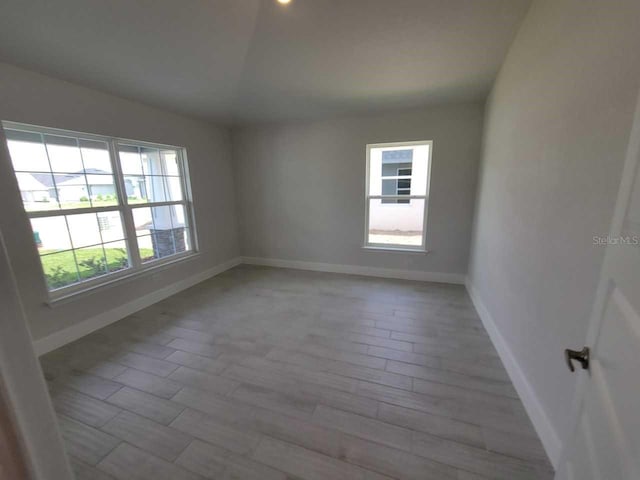 8309 SW 58th Ave, Ocala, FL 34476 - empty room with healthy amount of natural light, light wood finished floors, and vaulted ceiling