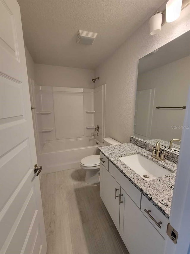 8309 SW 58th Ave, Ocala, FL 34476 - full bathroom with a textured ceiling, vanity, a textured wall,  shower combination, and wood finished floors