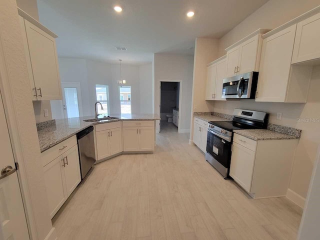 8309 SW 58th Ave, Ocala, FL 34476 - kitchen with appliances with stainless steel finishes, light stone counters, light wood-style floors, a peninsula, and recessed lighting