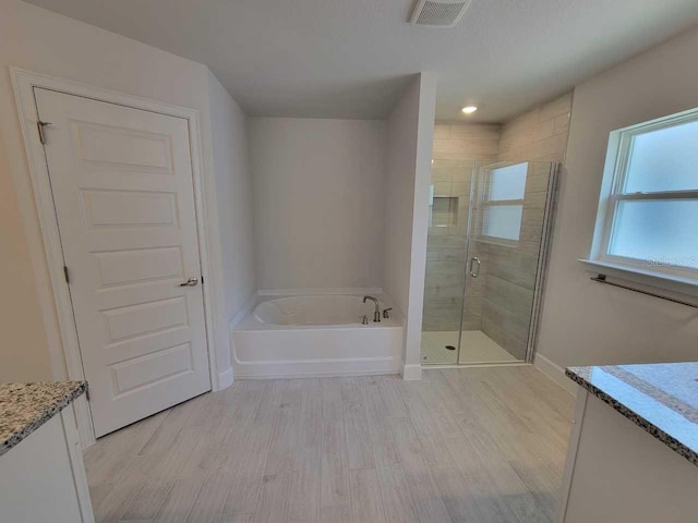 8309 SW 58th Ave, Ocala, FL 34476 - bathroom with vanity, wood finished floors, a garden tub, and a stall shower
