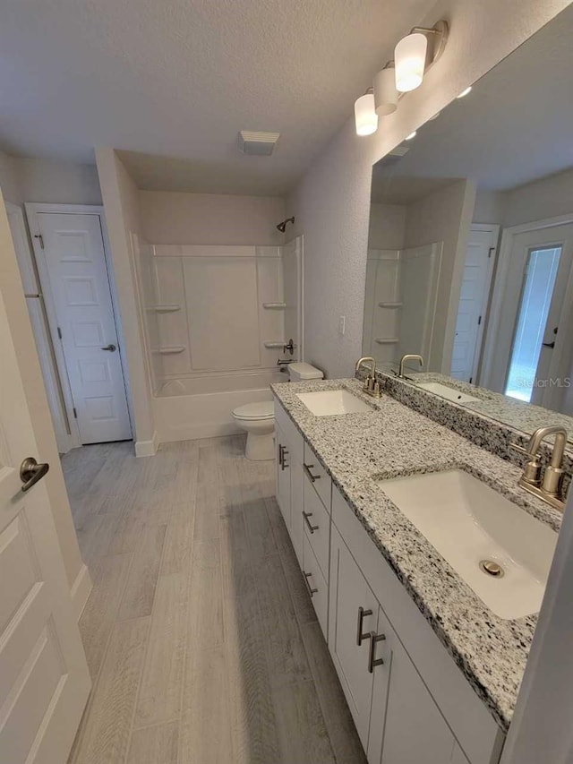 8309 SW 58th Ave, Ocala, FL 34476 - full bath with a textured ceiling, double vanity,  shower combination, and wood finished floors