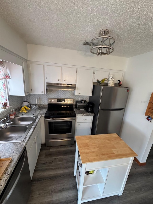 kitchen with stainless steel appliances, sink, white cabinets, and dark hardwood / wood-style floors