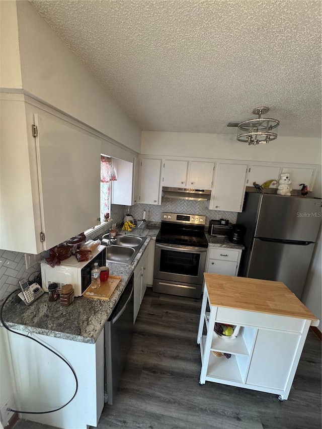 kitchen with sink, white cabinetry, stainless steel appliances, dark hardwood / wood-style floors, and dark stone counters