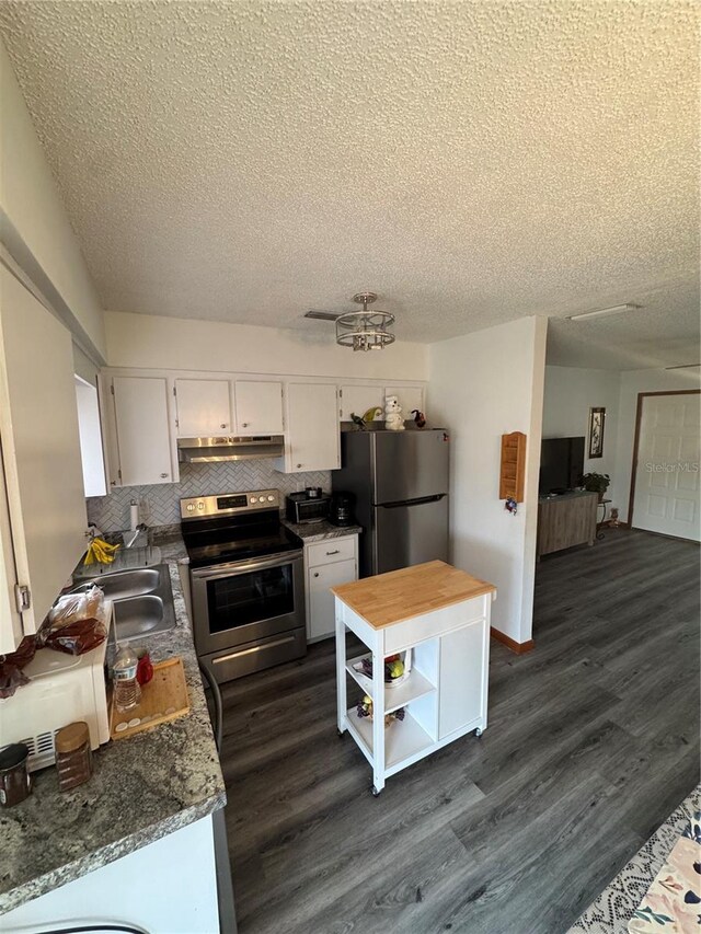 kitchen with dark stone countertops, white cabinetry, dark hardwood / wood-style flooring, and appliances with stainless steel finishes