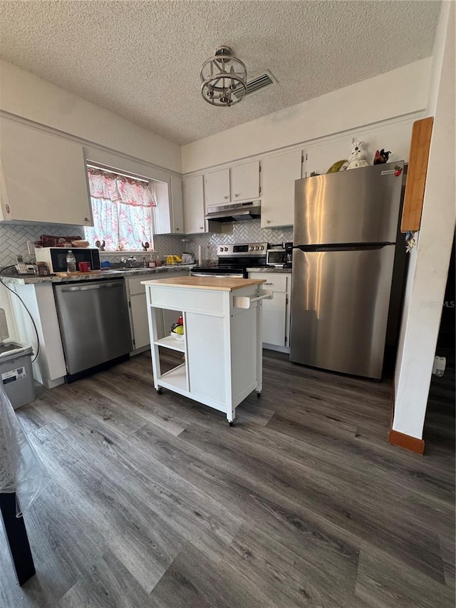 kitchen featuring stainless steel appliances, a center island, white cabinets, and dark hardwood / wood-style flooring