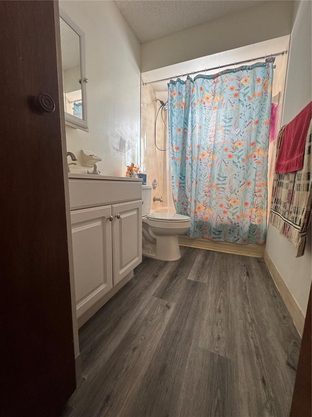 full bathroom with wood-type flooring, vanity, toilet, a textured ceiling, and shower / bath combo with shower curtain