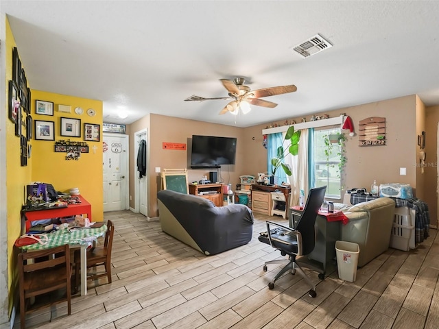 living room with light wood-type flooring and ceiling fan