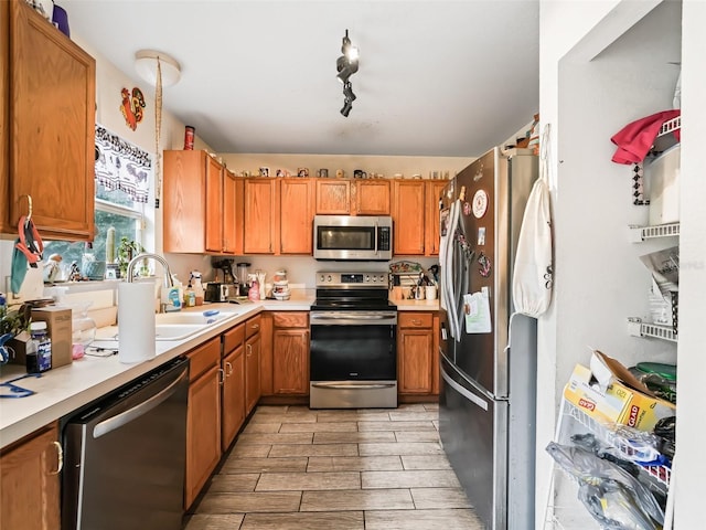 kitchen featuring sink, rail lighting, and appliances with stainless steel finishes