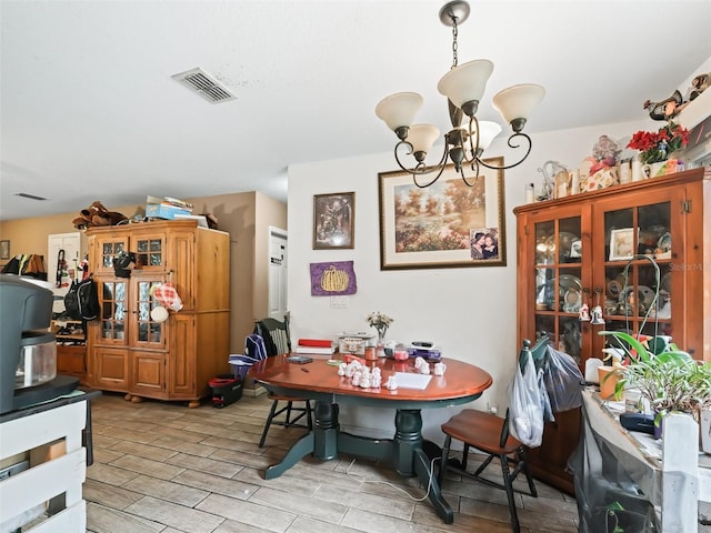 dining space with light hardwood / wood-style flooring and an inviting chandelier