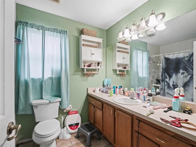 bathroom with vanity, tile patterned floors, a shower with curtain, toilet, and a wealth of natural light