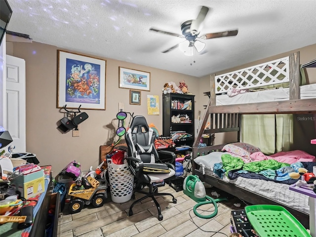 bedroom with ceiling fan, light hardwood / wood-style floors, and a textured ceiling