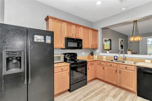 kitchen featuring sink, black appliances, an inviting chandelier, light hardwood / wood-style floors, and hanging light fixtures