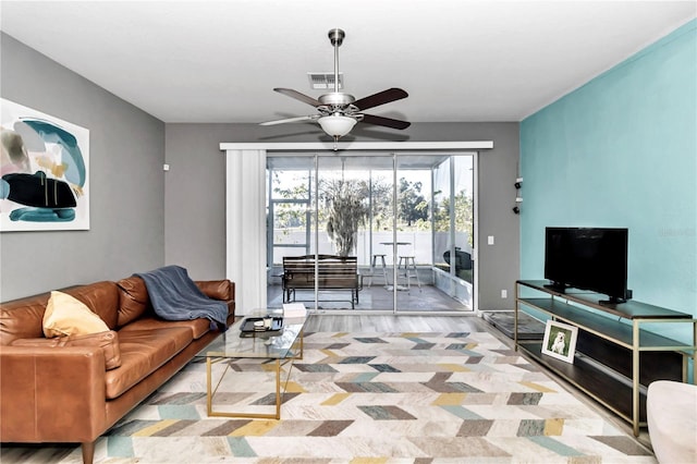 living room with light hardwood / wood-style flooring and ceiling fan