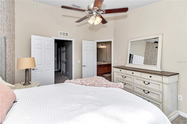 carpeted bedroom with ceiling fan and ensuite bath