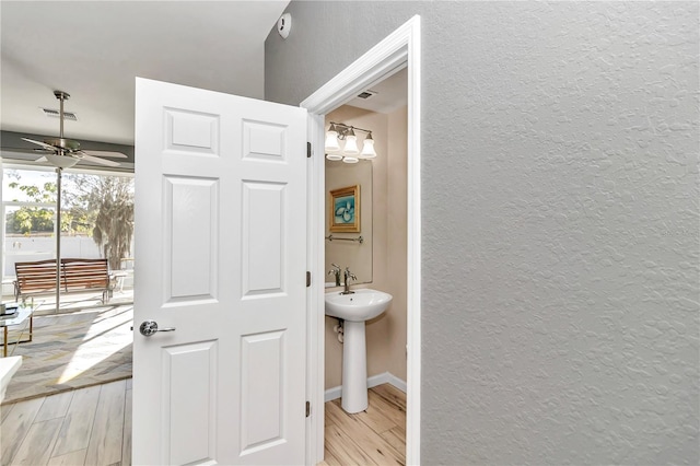 bathroom with hardwood / wood-style floors, ceiling fan, and sink