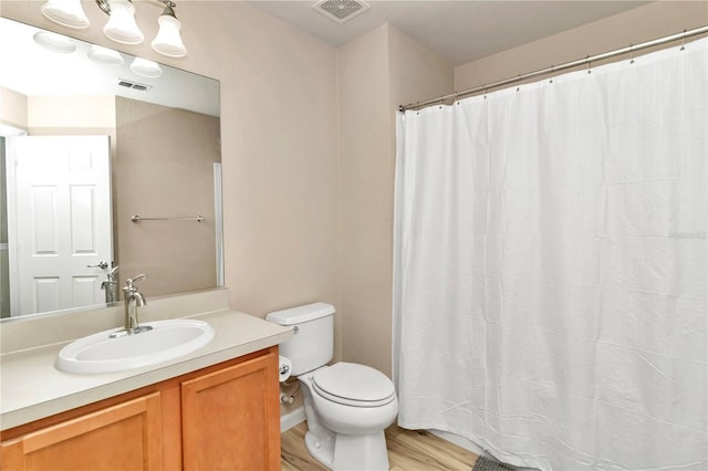 bathroom with toilet, vanity, and hardwood / wood-style flooring