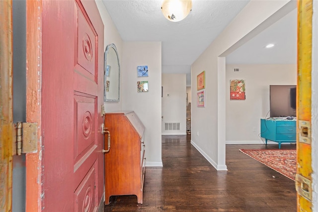 foyer entrance featuring dark hardwood / wood-style floors and a textured ceiling