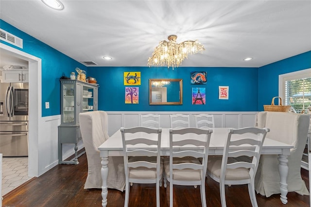 dining space with dark wood-type flooring and a notable chandelier