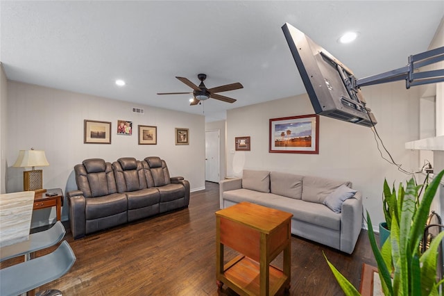 living room featuring ceiling fan and dark wood-type flooring