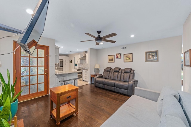 living room with dark hardwood / wood-style floors, a wealth of natural light, and ceiling fan