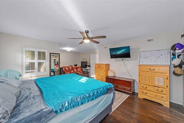 bedroom featuring a textured ceiling, ceiling fan, and dark wood-type flooring