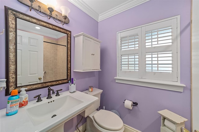 bathroom featuring crown molding, toilet, sink, and a tile shower