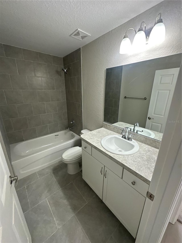 full bathroom featuring visible vents, a textured wall, tub / shower combination, a textured ceiling, and vanity