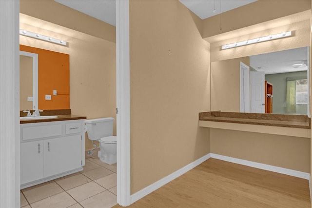 bathroom featuring toilet, vanity, and hardwood / wood-style flooring