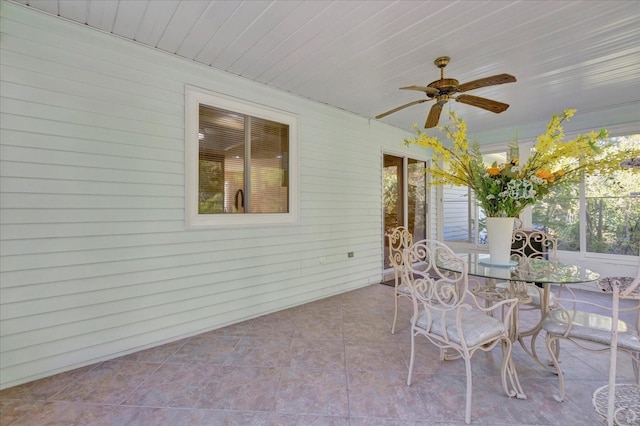 unfurnished sunroom with a wealth of natural light, wooden ceiling, and ceiling fan