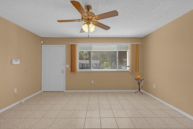 tiled spare room with a textured ceiling and ceiling fan