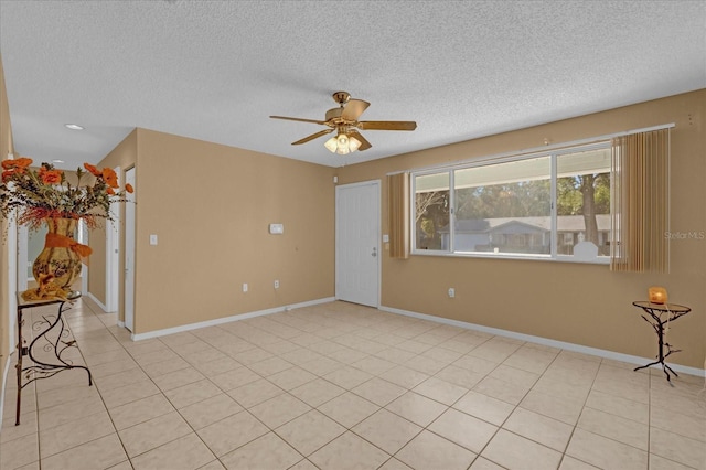 tiled spare room featuring ceiling fan and a textured ceiling