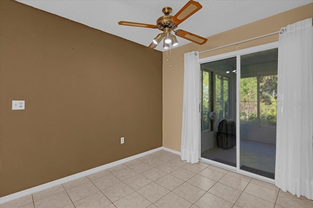 unfurnished room featuring ceiling fan, light tile patterned floors, and a textured ceiling