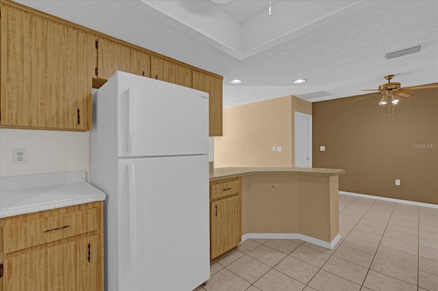 kitchen featuring ceiling fan, white fridge, light tile patterned floors, and a textured ceiling