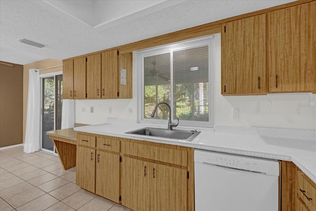 kitchen featuring light tile patterned floors, a textured ceiling, white dishwasher, and sink