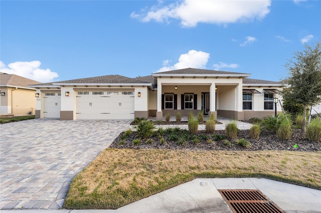 prairie-style home featuring a front yard, a garage, and covered porch